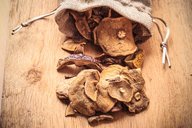 istock Dry mushrooms in sack on wooden table. 1083625034