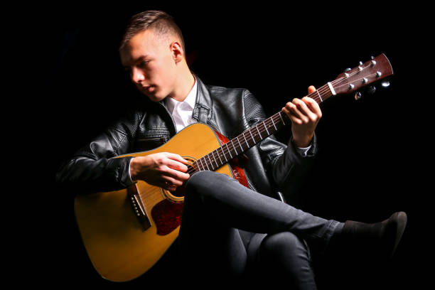 istock Young men playing the guitar with black background 1083626956