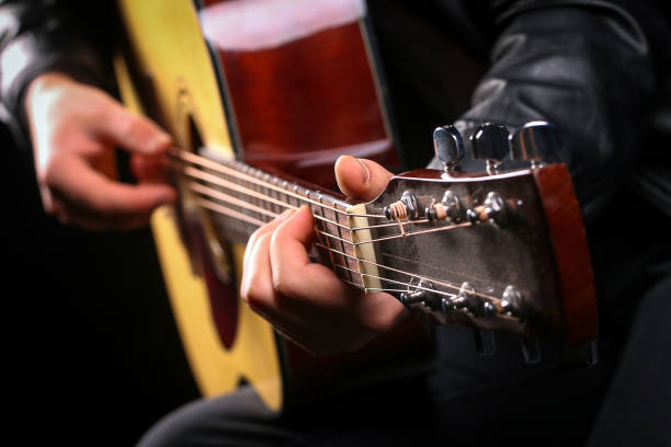istock Young men playing the guitar with black background 1083626996