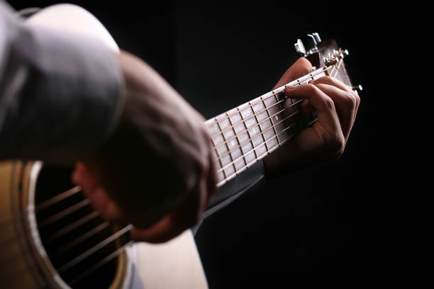 istock Young men playing the guitar with black background 1083627010