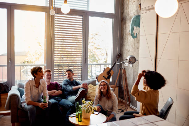 Friends Living Together Friends Living Together. Sitting in The Living Room, Having Fun and Playing Charades Together pantomime stock pictures, royalty-free photos & images