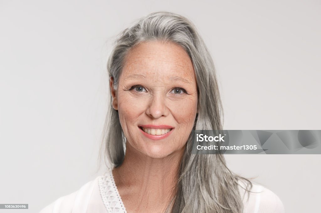 Portrait of senior woman Portrait of smiling senior woman on white studio background. Midsection Stock Photo
