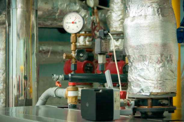 istock Manometer - pressure sensor at boiler room. Sensor with black and red arrows. The arrows show a lot of pressure. Pipes at background. Selective focus. heating season industry. 1083635278