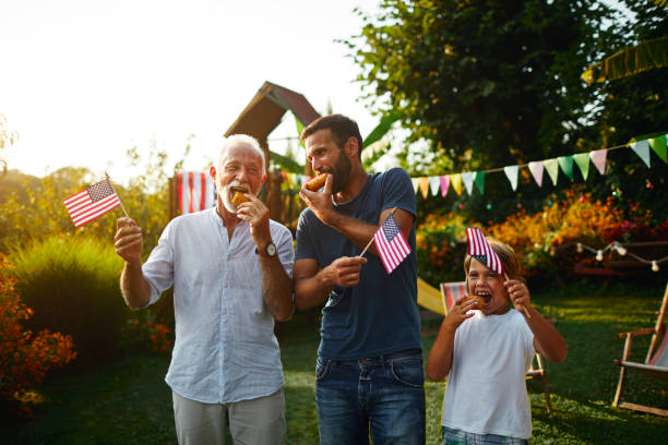 tres generaciones de hombres celebrando el 4 de julio - child picnic smiling outdoors fotografías e imágenes de stock