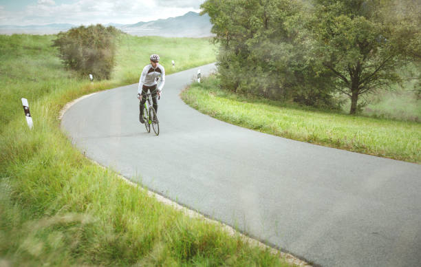 istock Cyclist training on a small road in the countryside 1083639952