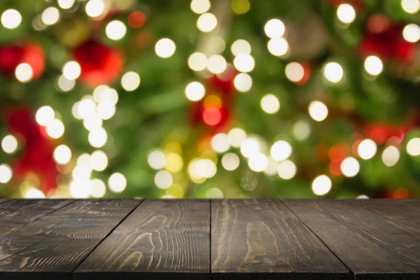 istock Wooden dark tabletop and blurred christmas tree bokeh. Xmas background for display your products. 1083639968