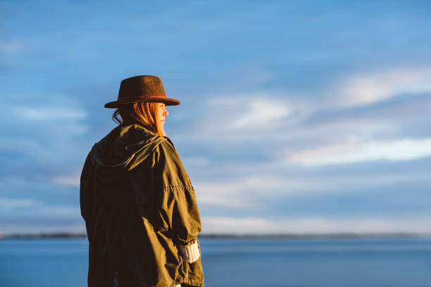 istock Woman looking out at  sea against cloudy sky 1083641906