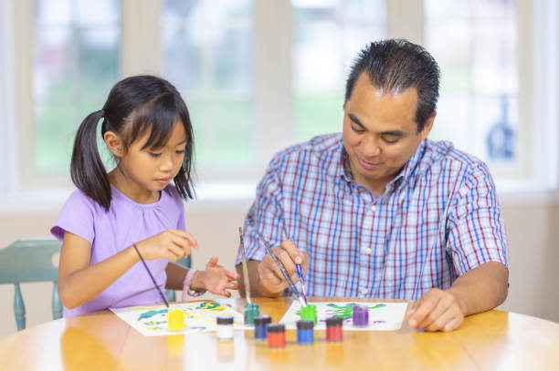 istock Father and daughter painting 1083644676