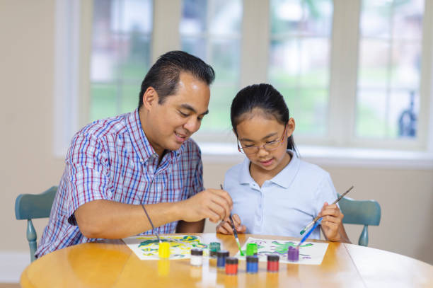 istock Girl painting with dad 1083644678