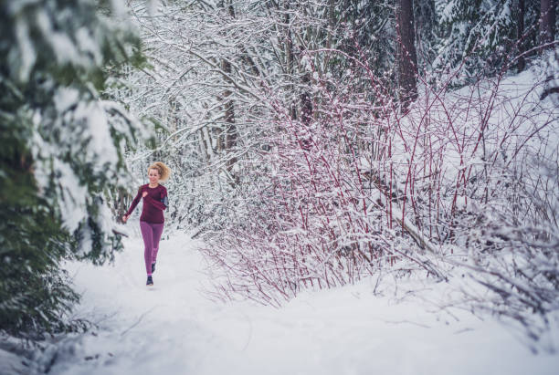istock Female running in forest at winter day. 1083646428