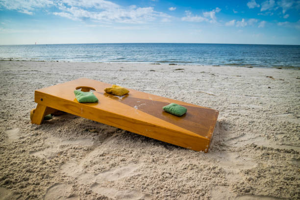 un jeu populaire du maïs trou par un beau temps à fort myers, floride - cornhole leisure games outdoors color image photos et images de collection