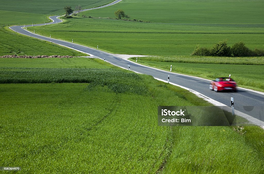 Voiture de sport rouge accélérer sur Rural route sinueuse au printemps - Photo de Voiture de sport libre de droits