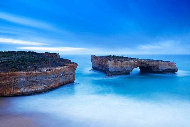 london bridge auf die great ocean road, australien im morgengrauen - the twelve apostles stock-fotos und bilder