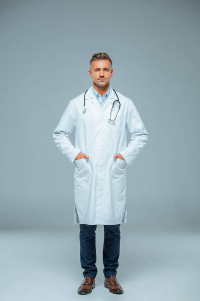 istock handsome doctor with stethoscope looking at camera on grey 1083652662