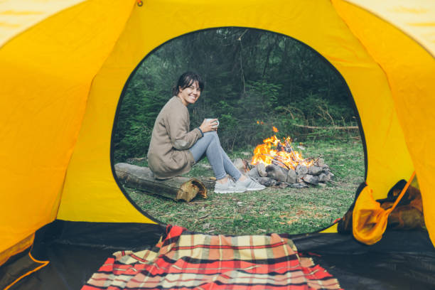 istock tent with viewing on fire with young woman drinking tea 1083652890