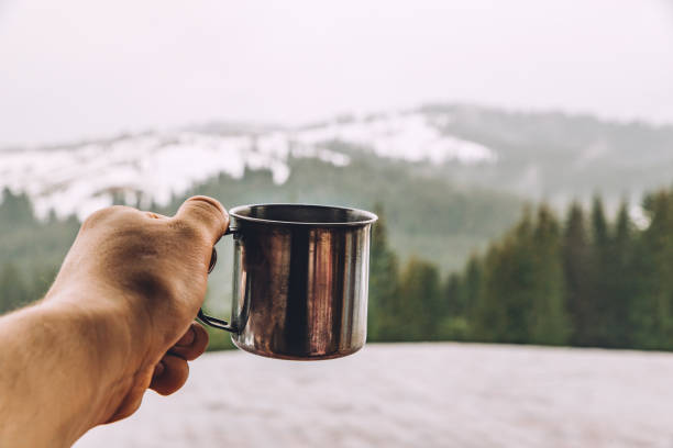 istock man hand hold metal cup with warm up tea 1083653360