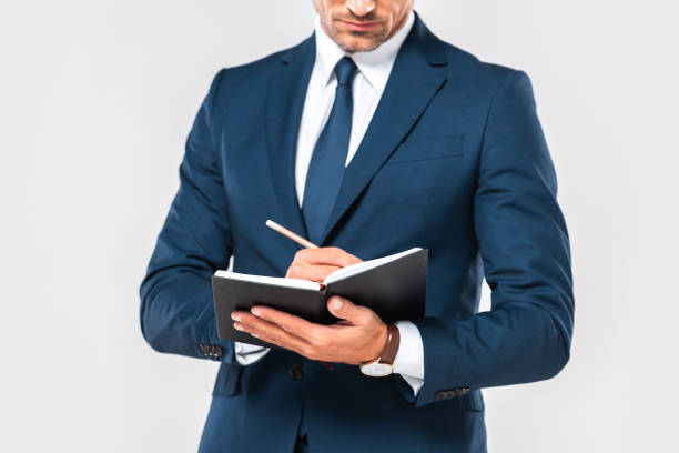 istock cropped image of businessman writing something in notebook isolated on white 1083657610