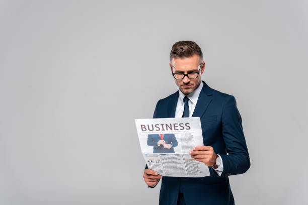 istock handsome businessman reading newspaper isolated on white 1083657782