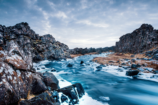 This photograph is of the winter landscape with the Öxará river in Thingvellir National Park, a travel destination along the Golden Circle in Iceland.