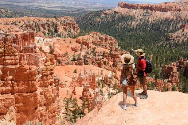Couple on hiking trip enjoying beautiful  mountain landscape in Utah. Couple on hiking trip enjoying beautiful  mountain landscape,  Friends relaxing on top of the mountain.  Bryce Canyon National Park, Utah, USA. bryce canyon national park stock pictures, royalty-free photos & images