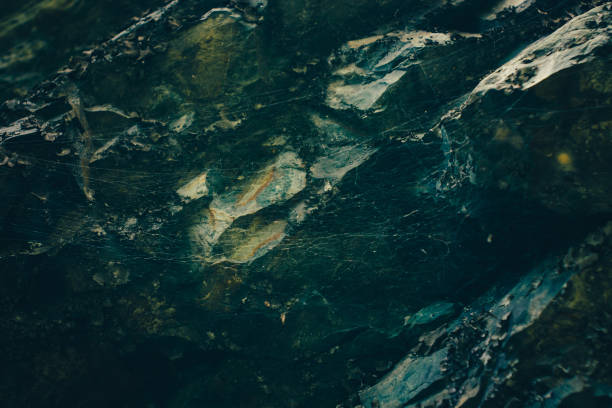 istock Dark green rocky surface with cobweb in cave in darkness close-up. Atmospheric horror background with copy space. Creepy shadows in scary dungeon. Terrible dark place in deep cave. Fear of spiders. 1083676066