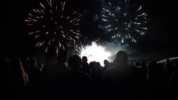 istock New year concept - cheering crowd and fireworks 1083678704