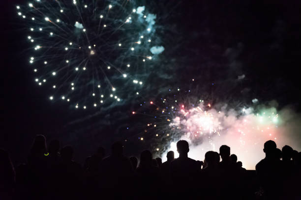 istock New year concept - cheering crowd and fireworks 1083678842