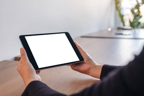 istock Mockup image of hands holding black tablet pc with blank white screen while sitting in office 1083680016