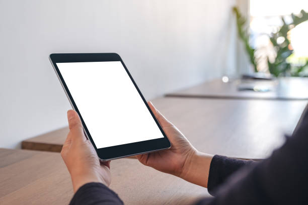istock Mockup image of hands holding black tablet pc with blank white screen while sitting in office 1083680056