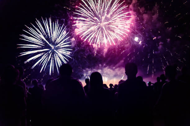 istock New year concept - cheering crowd and fireworks 1083680084