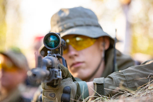 sniper armed with large caliber, sniper rifle, shooting enemy targets on range from shelter, sitting in ambush.