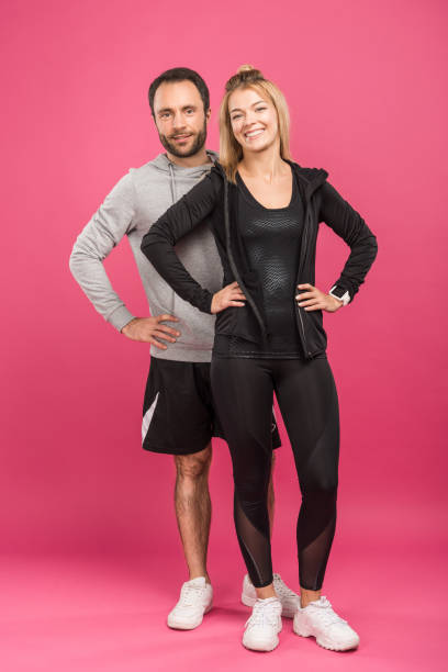 istock beautiful happy sportive couple posing on pink 1083681184