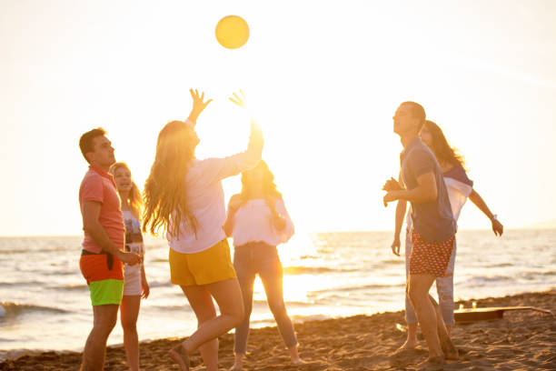 istock Group of young people playing volleyball on the beach 1083681402