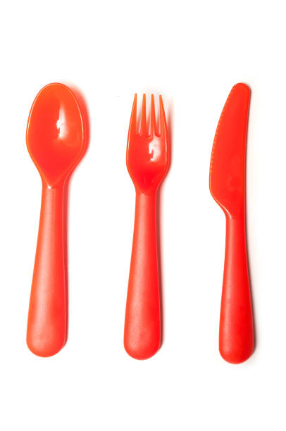istock orange baby plastic spoon, fork and knife on white background 1083684136