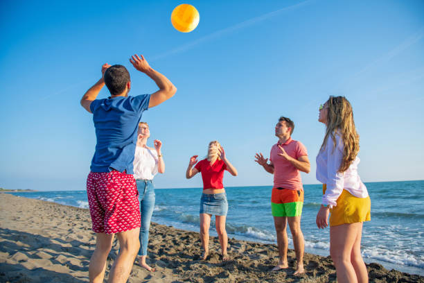 istock Group of young people playing volleyball on the beach 1083686076