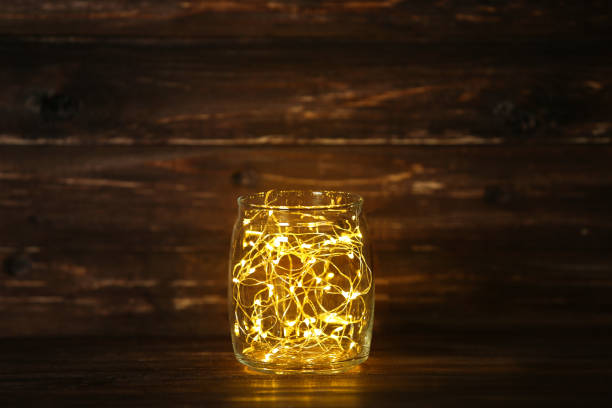 istock Garland lights in glass jar on brown background 1083686452