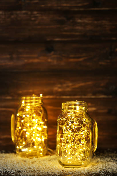 istock Garland lights in glass jars on brown background 1083686620