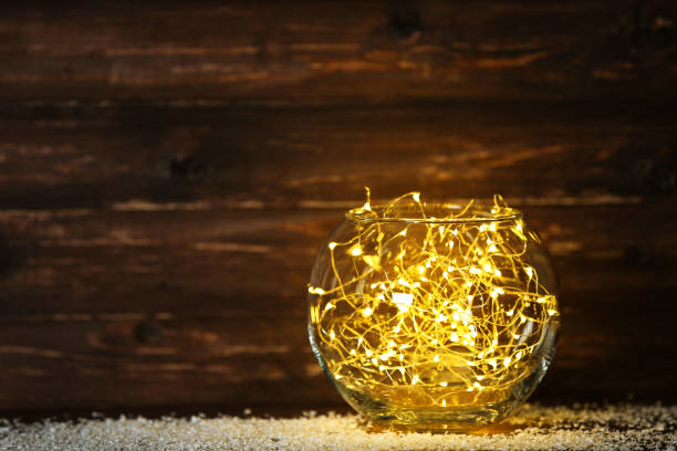 istock Garland lights in glass bowl on brown background 1083686778