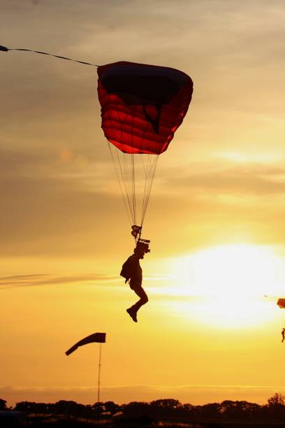 istock Low Angle View Of Silhouette Man Paragliding Against Orange Sky 1083686810