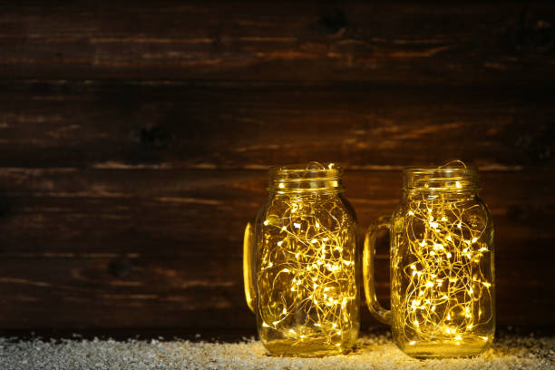 istock Garland lights in glass jars on brown background 1083687084