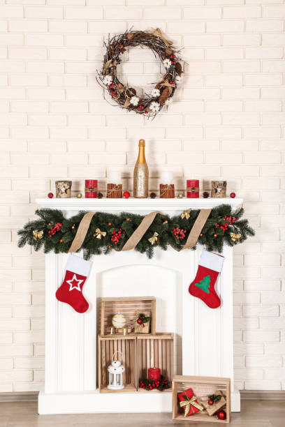 istock White decorated fireplace with wreath on brick wall background 1083689970