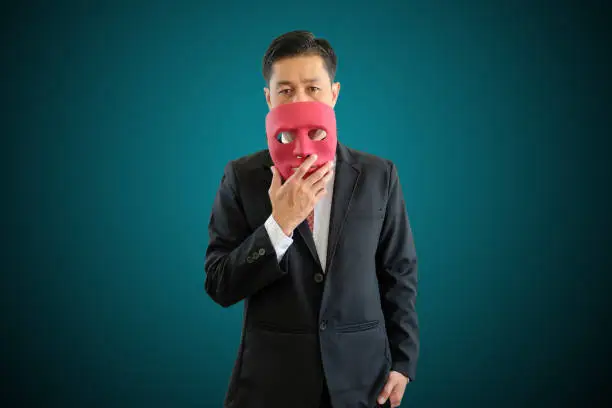 Asia businessman is wearing red mask on geen background with clipping path.