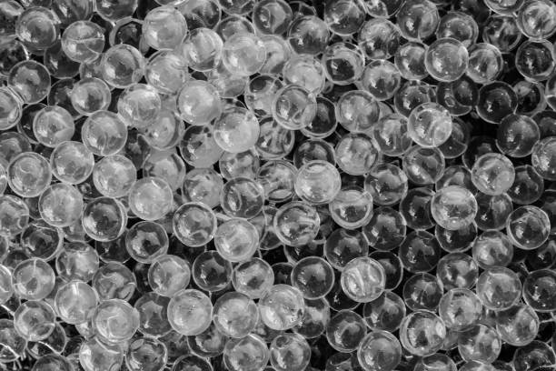 pelotas de gel de agua blanco y negro con bokeh. gel polímero. gel de sílice. bolas de hidrogel blanco y negro. bola líquido de cristal con la reflexión. fondo de textura blanco y negro. macro - glass bead fotografías e imágenes de stock