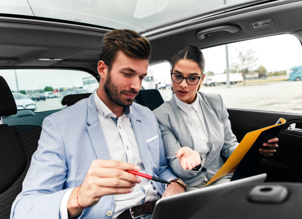 istock Young business people working together while traveling by a car. 1083704050