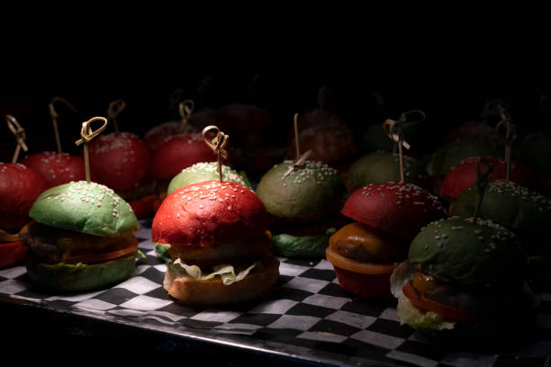 Several red and green burgers on the showcase