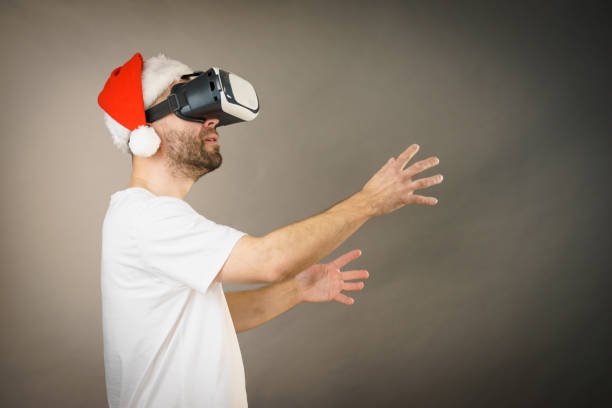 istock Man in virtual reality goggles and santa hat 1083717360