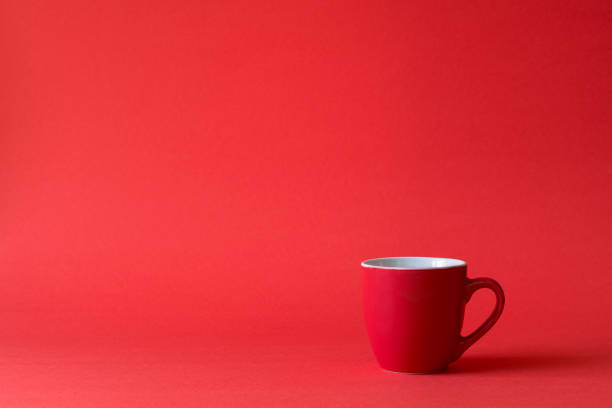 istock Red cups of tea or coffee on red paper background. Copy space 1083718014