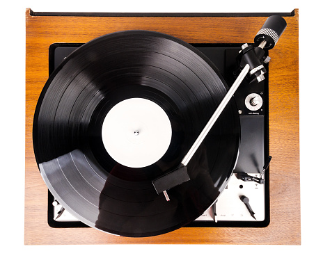 Vintage turntable with a black vinyl isolated on white. Wooden plinth. Retro audio equipment.