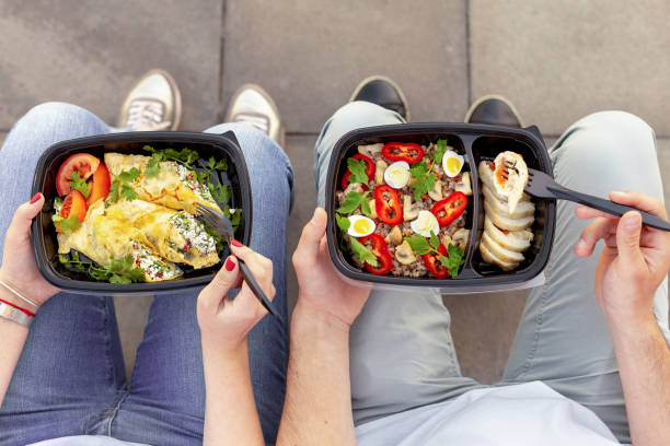 Healthy lunch outdoor, top view Couple enjoying take away healthy lunch outdoors, top view food state stock pictures, royalty-free photos & images