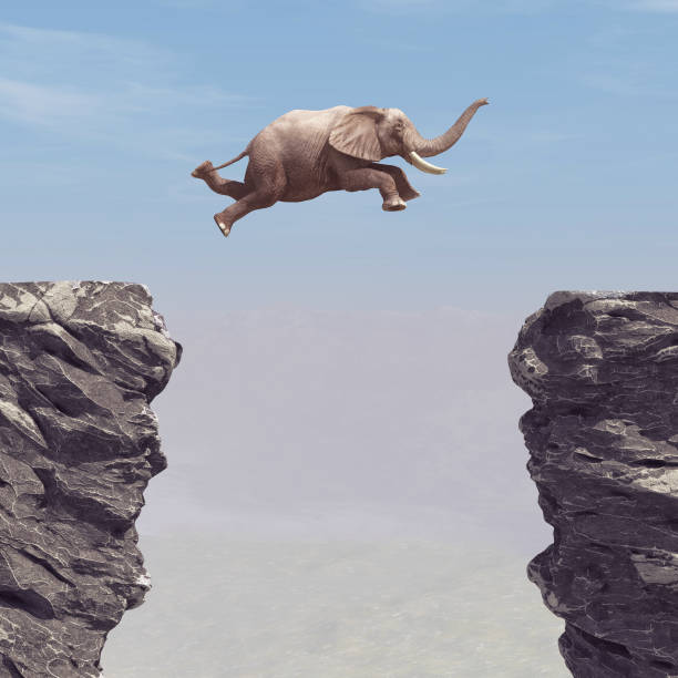 istock An elephant jumping over a chasm. This is a 3d render illustration 1083724536